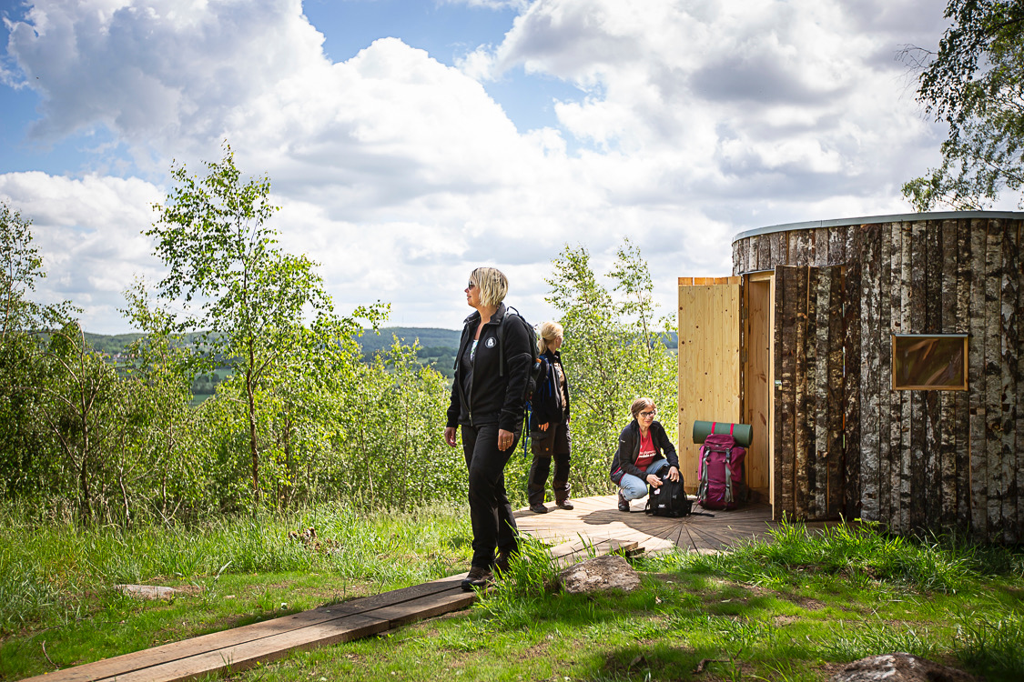 Three hikers just outside one of the new shelters Birk and Birka at Hovdala hiking centre.