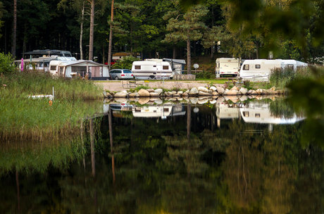 Campingplats med husvagnar invid vatten.