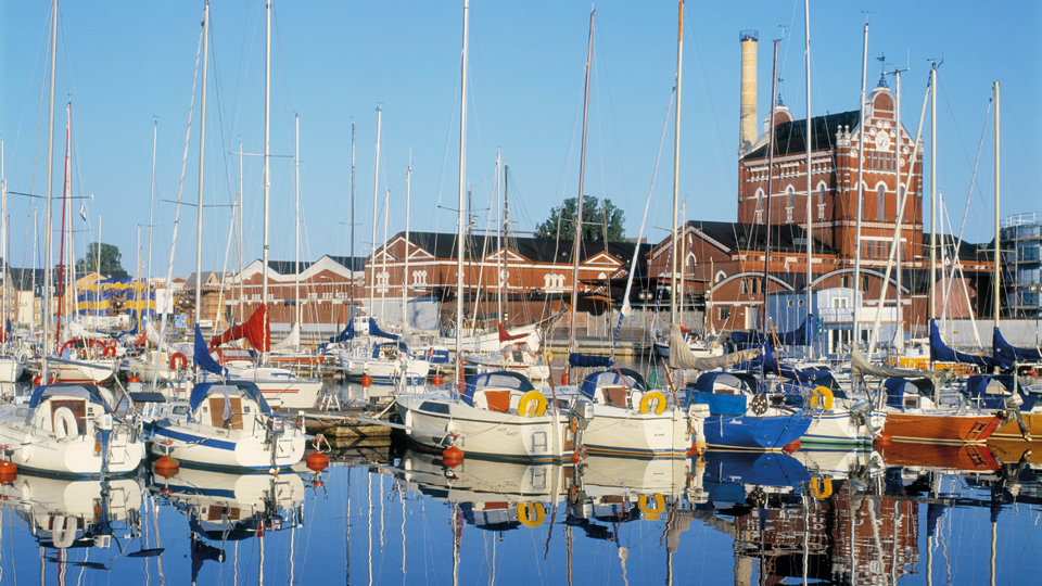 Längs hamnen i Åhus ligger många segelbåtar ankrade.